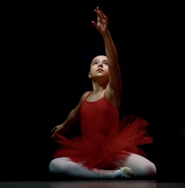 Fetiță în costum de balet roșu