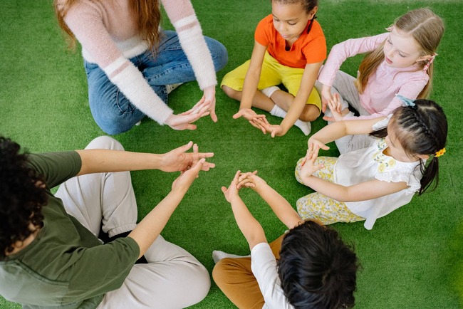 Copii si educatori se joaca in cerc