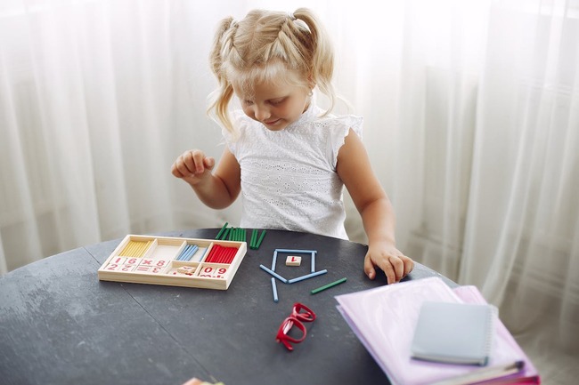 Fata care invata matematica cu bete prin metoda montessori