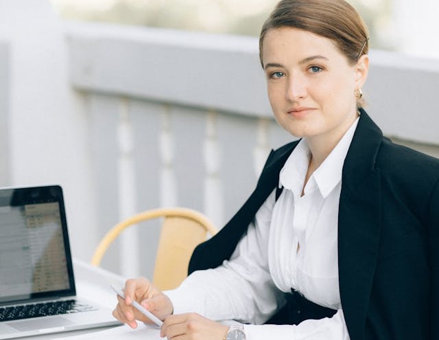 Femeie la birou cu pixul in mana