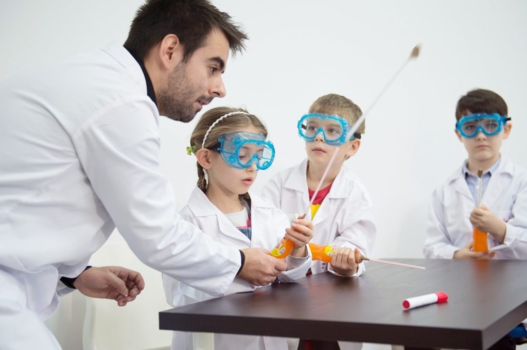 trainer si copii care fac experimente stiintifice
