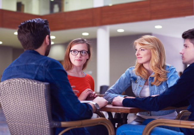 Parinti si adolescenti care discuta la masa