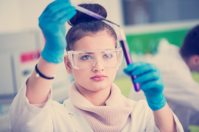 fata cu ochelari de protectie intr-un laborator de chimie