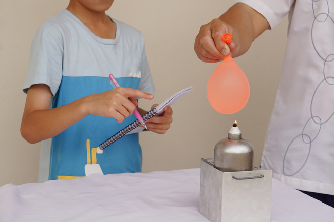 Elev care face un experiment cu un balon